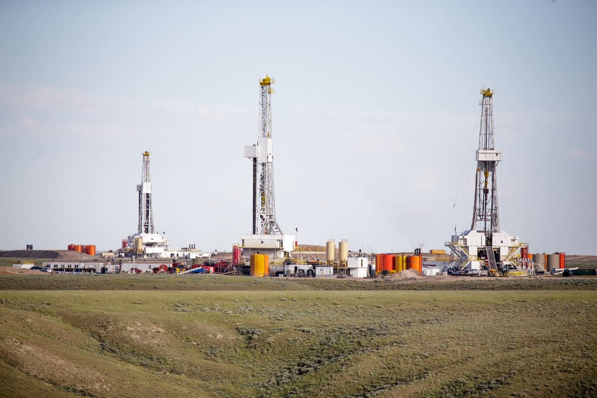 Three fracking towers in a field for gas seam extraction