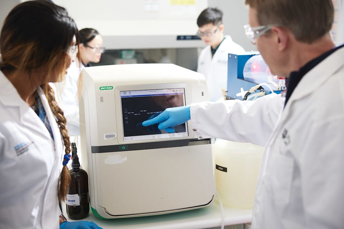 Dr Rekha Shandre Mugan and Dr Stewart Fabb in labcoats in front of scientific apparatus.