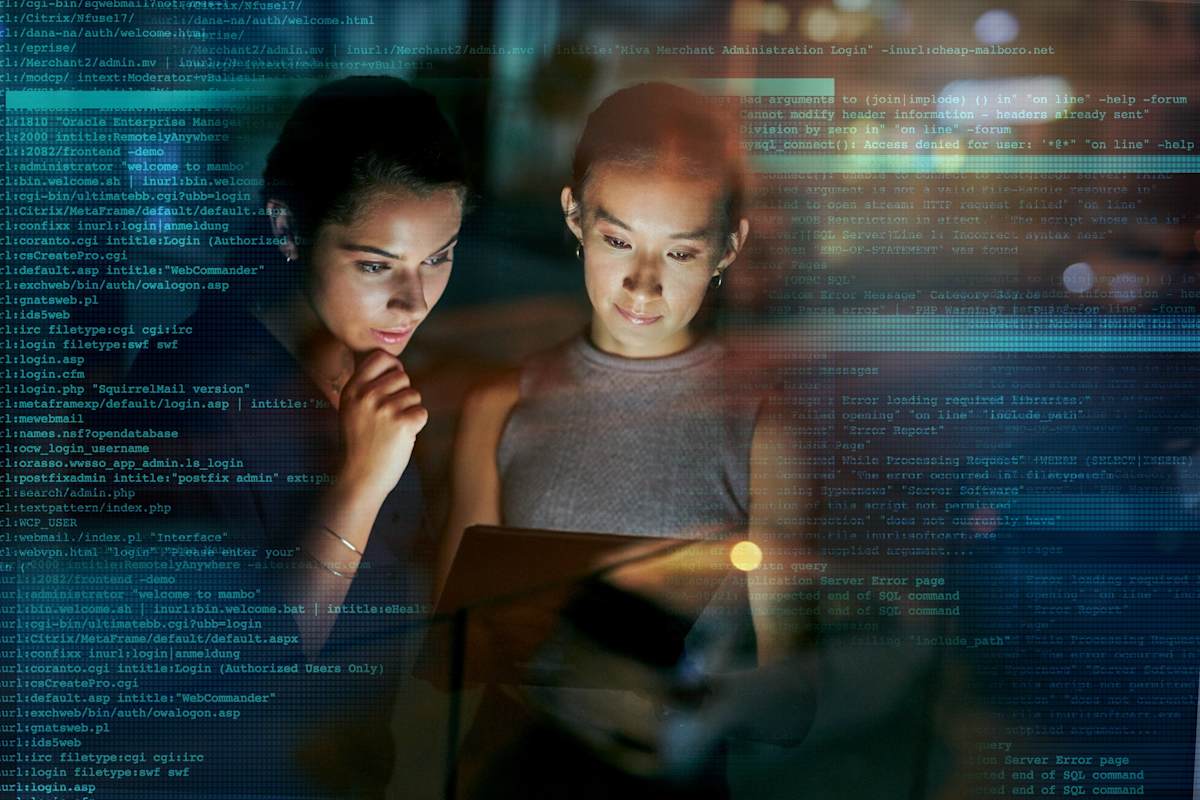 two young programmers using a digital tablet during a late night at work