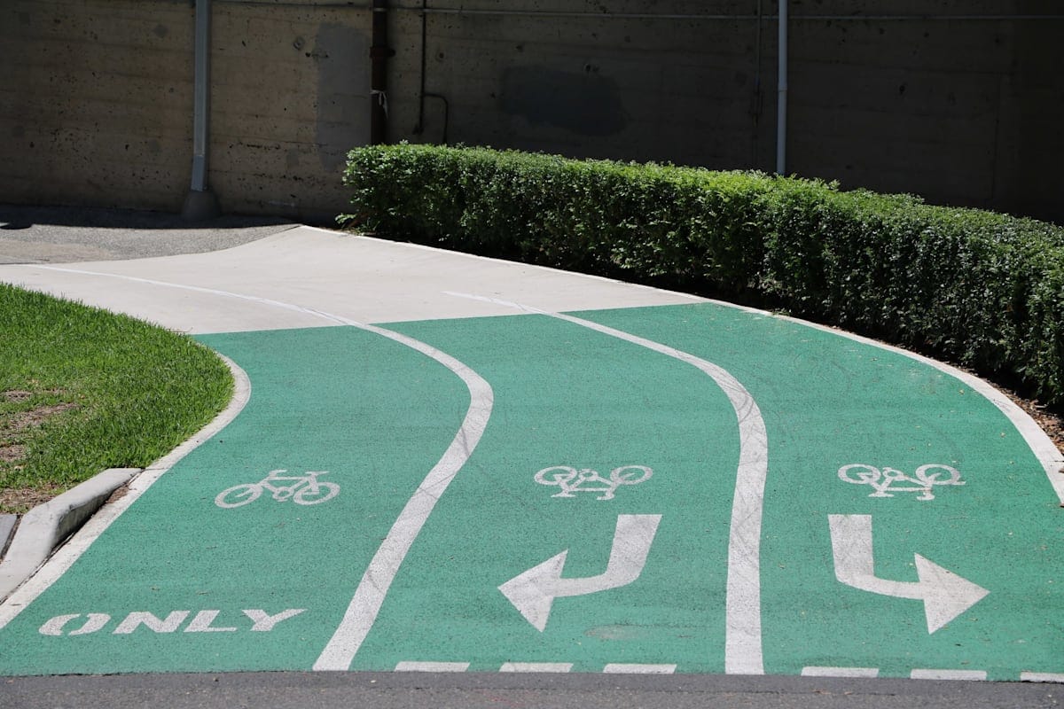 A green three-lane bike path with arrows pointed left and right
