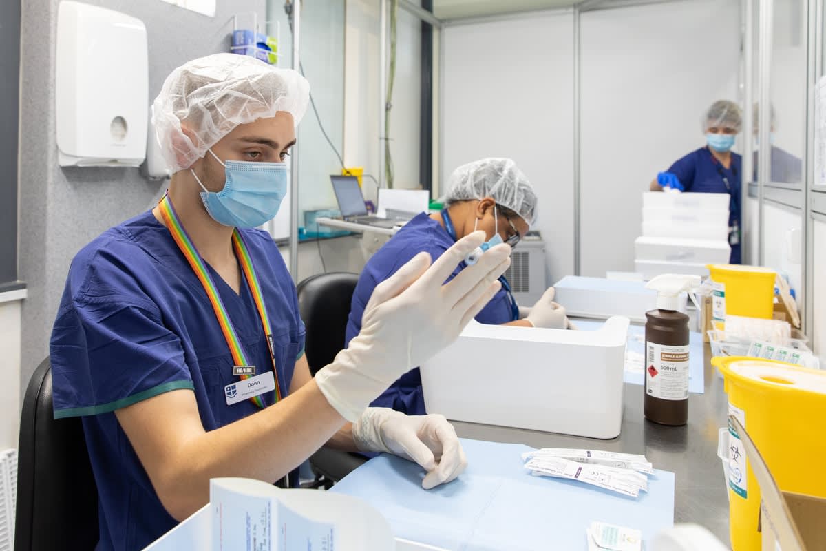 Two pharmacy students preparing vaccine vials at Royal Melbourne Hospital