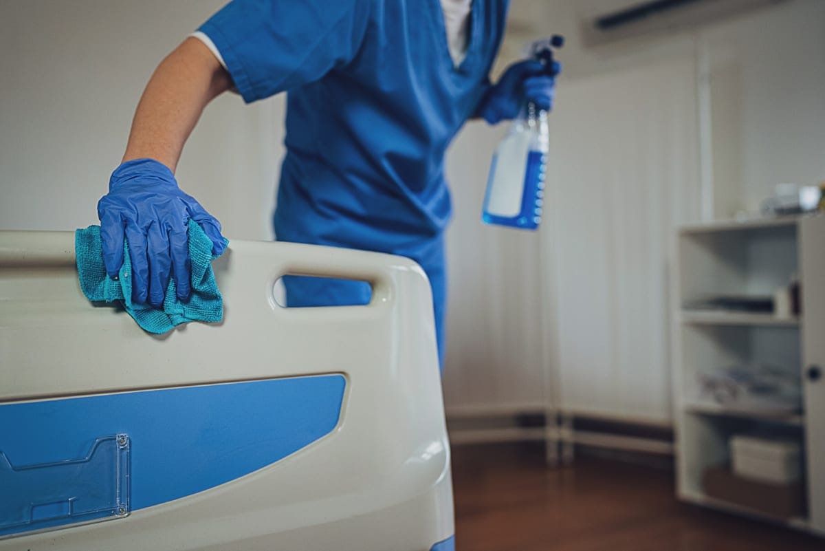 Hospital worker cleans equipment.