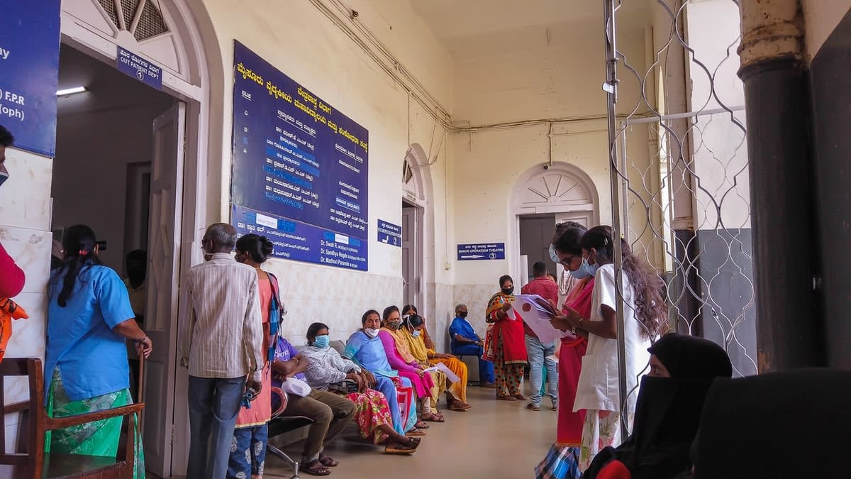 Patients wait outside a hospital in India