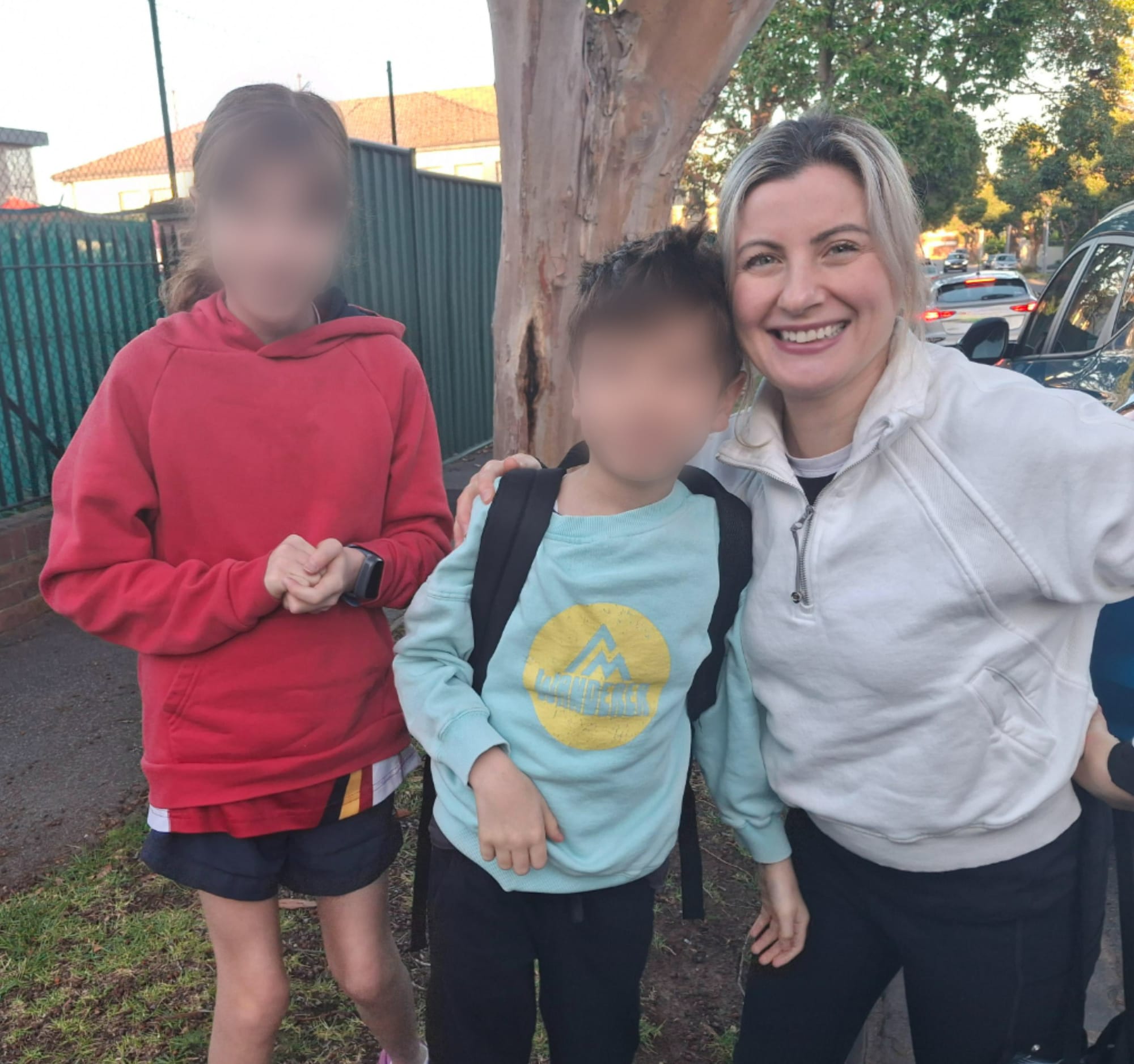 A smiling Angelina Piccolo with her two children, their faces blurred