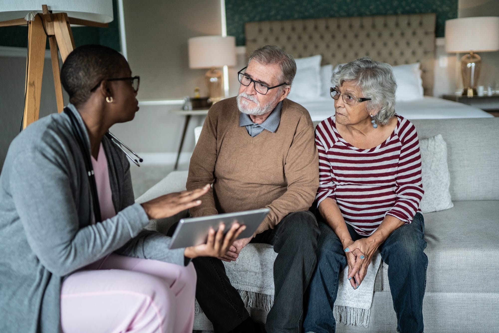 Nurse talking to senior couple patient at home