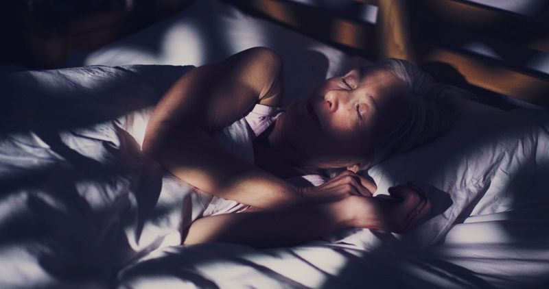 Older woman in bed having restless sleep