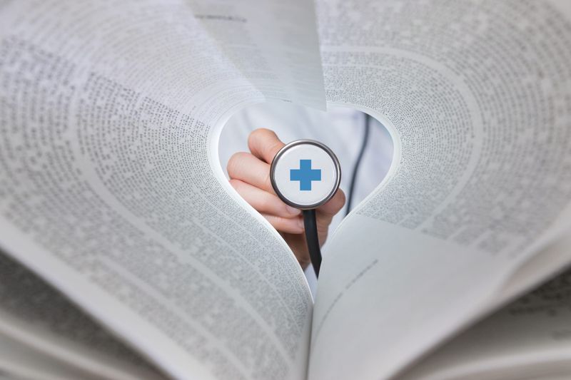 Health concept with stehoscope and the pages of a book.