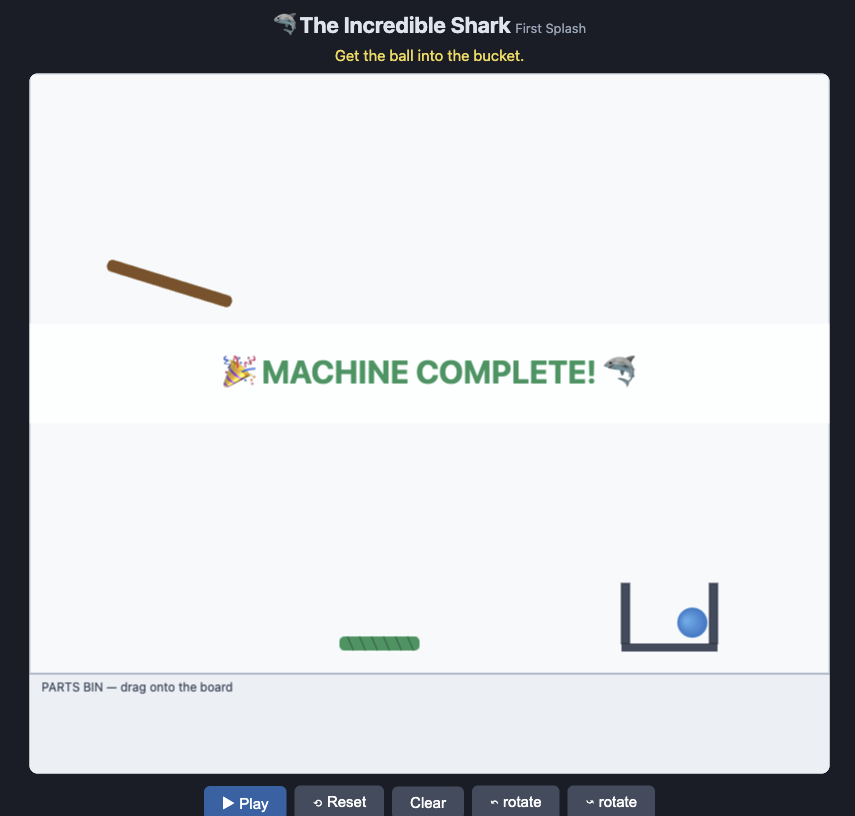 "The Incredible Machine" browser game showing a successful puzzle solution, with a blue ball resting in an open bucket in the lower right, a diagonal ramp in the upper left, and a "MACHINE COMPLETE!" success message displayed in the center of the play area.