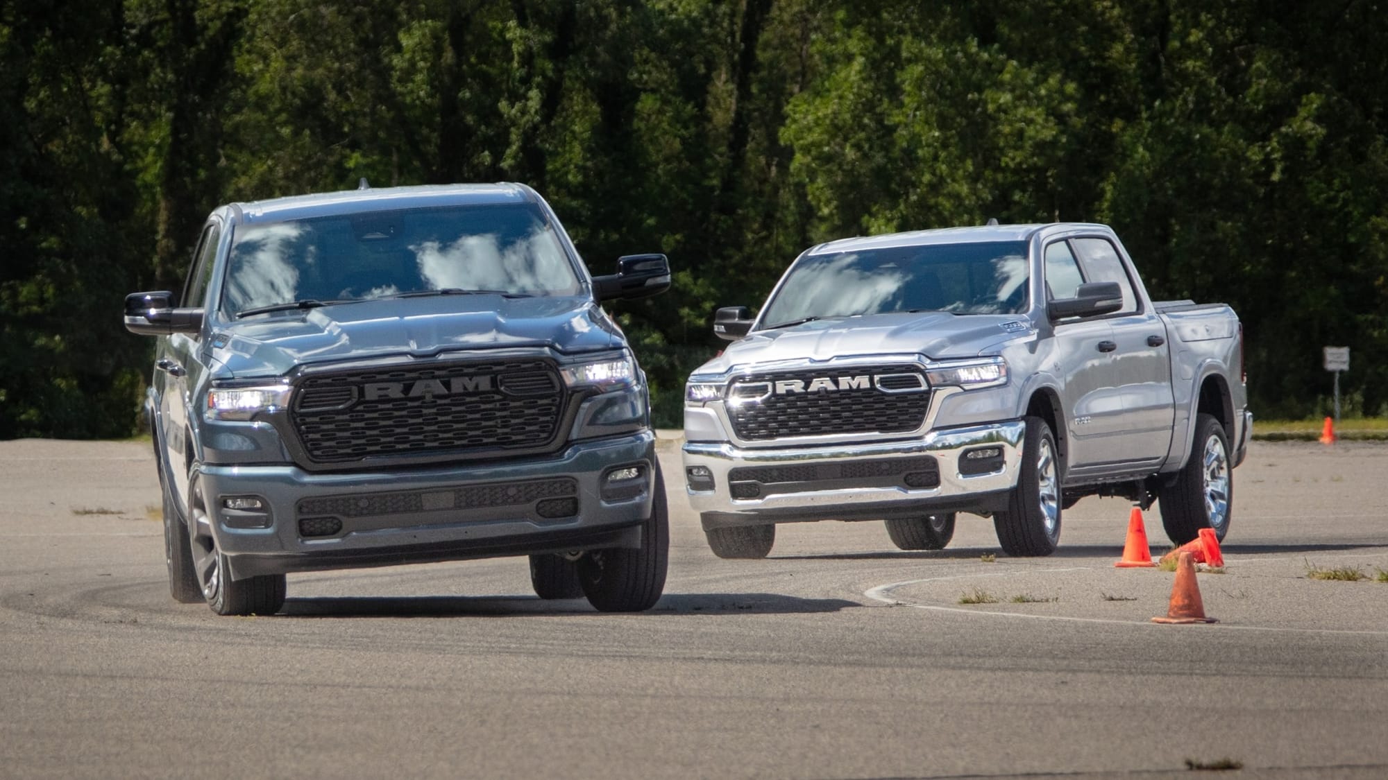 A pair of 2026 Ram 1500 pickups demonstrating their cornering ability on Stellantis' test track.