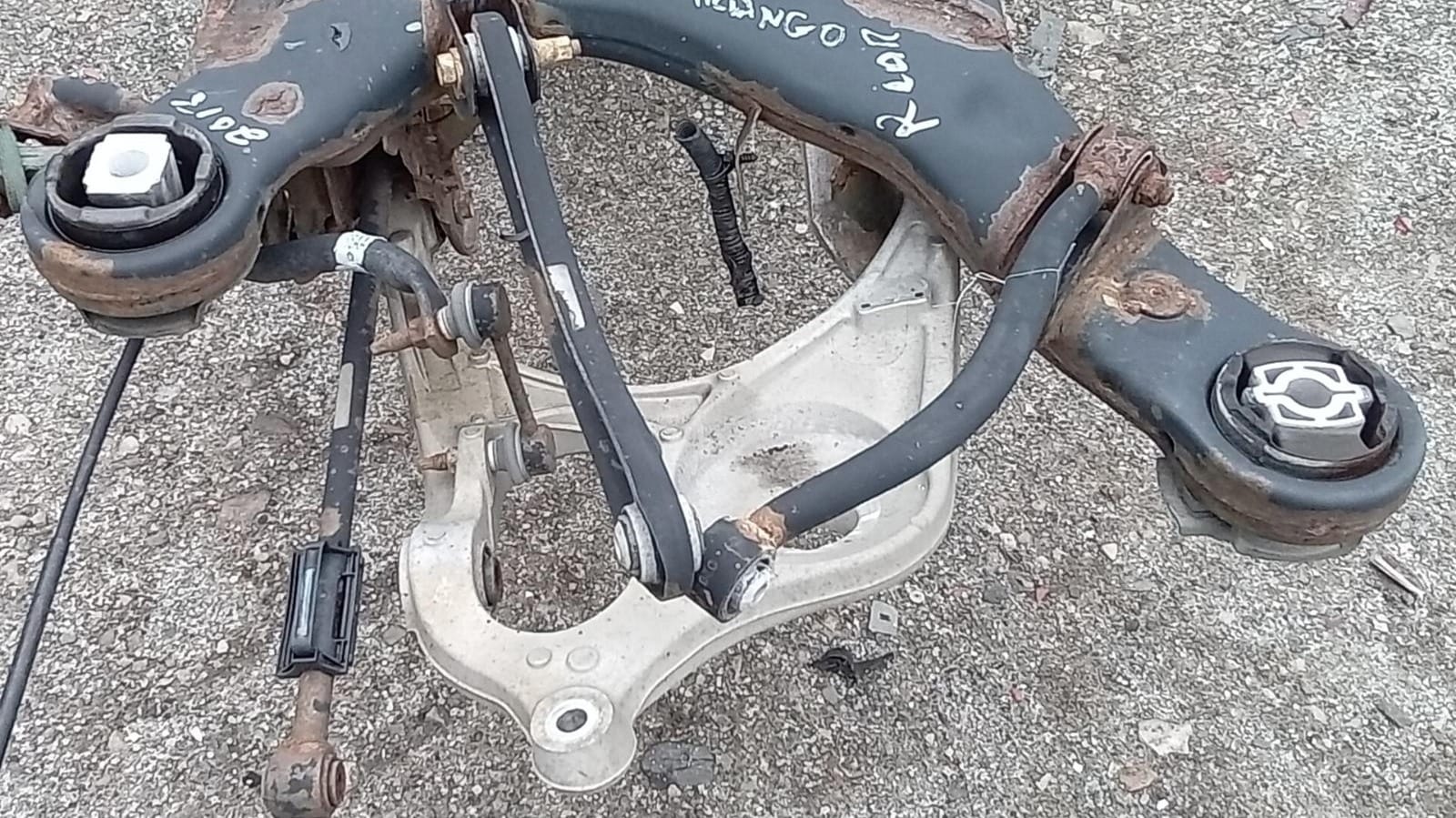 The lower isolator seats on the pocket of the lower rear control arm for the 2021 to 2023 Jeep Grand Cherokee models.