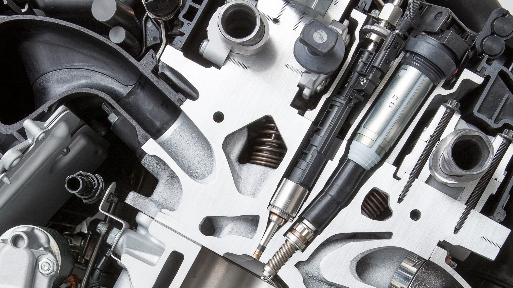 Some manufacturers, like BMW, will install the injector and spark plug offset from each other, others will insert it between the intake ports.