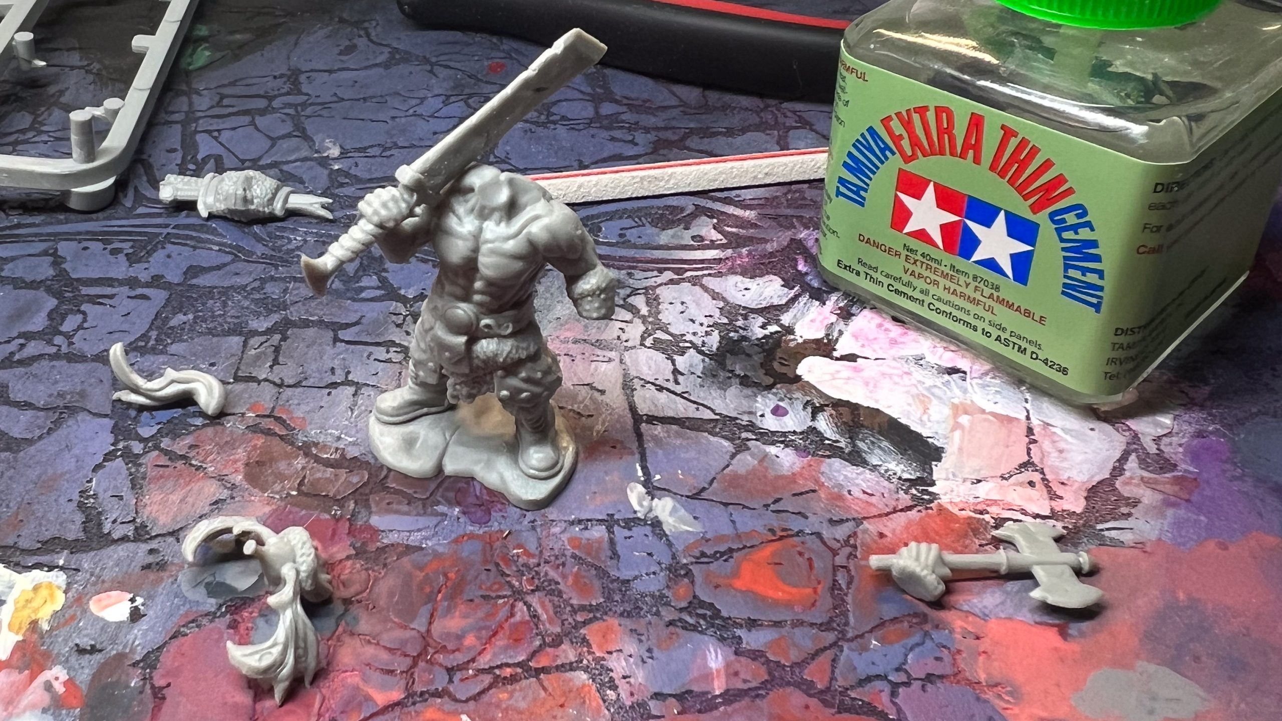 A frameworks model, in the middle of assembly on a dry palette with a bottle of plastic cement