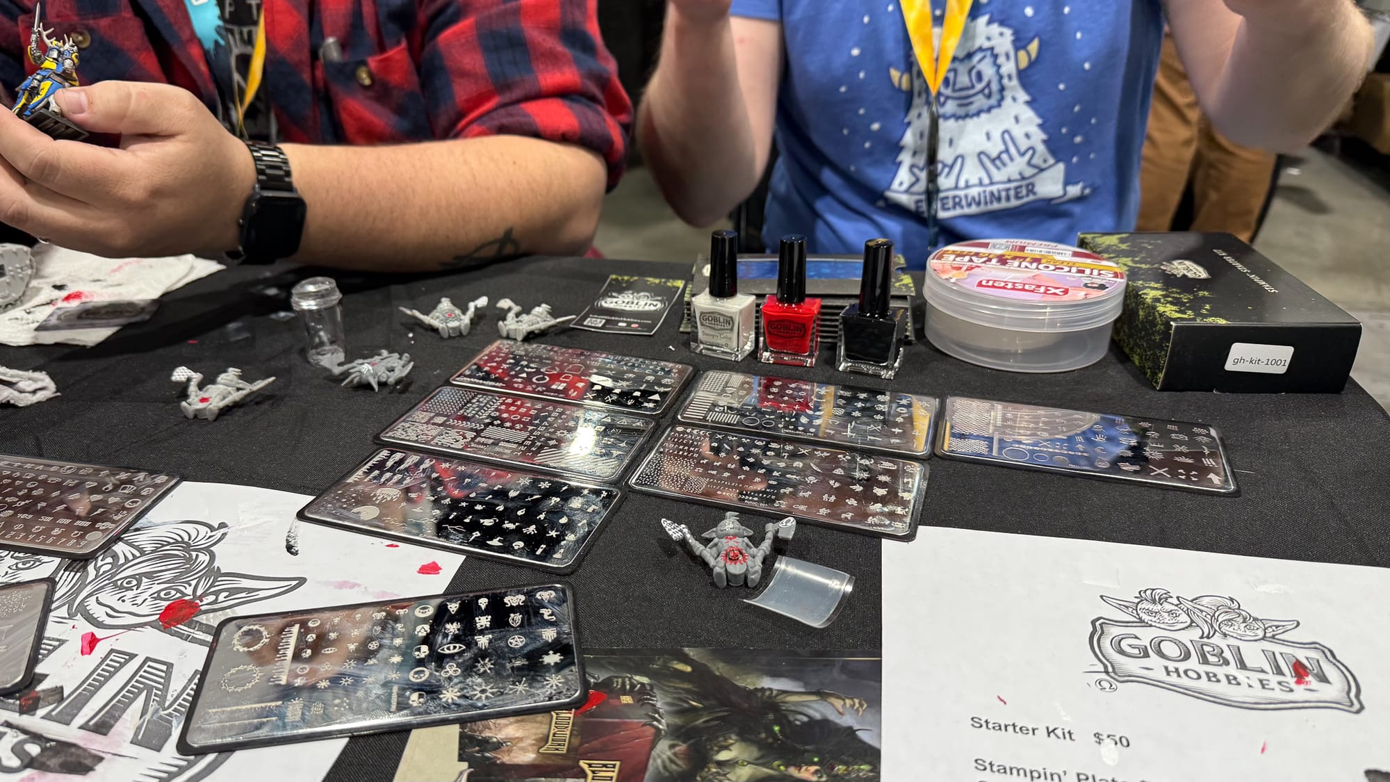 A photo of the Stampin' Kit at Adepticon, with several plates, paints, and the tool.