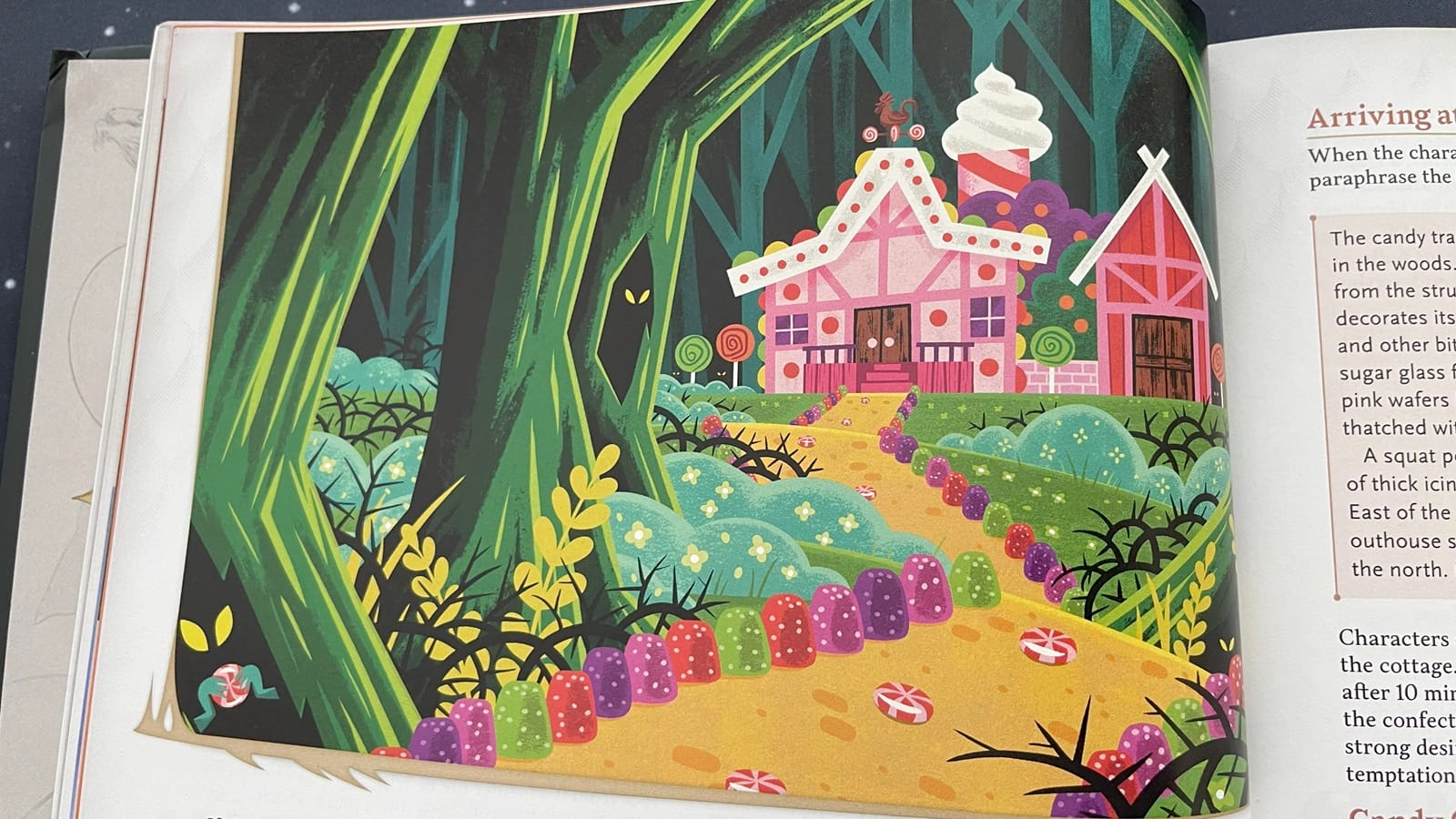 A photo of a painting of a life-sized candy and gingerbread house with a trail lined with giant gumdrops and peppermints. 