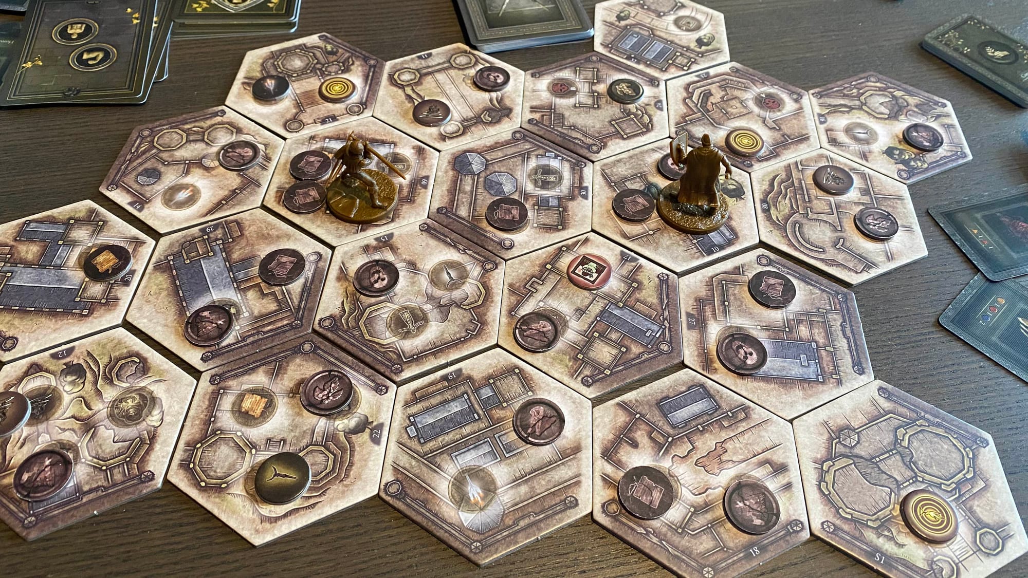 Two Tarnished miniatures on a map of hex tiles covered in location tokens