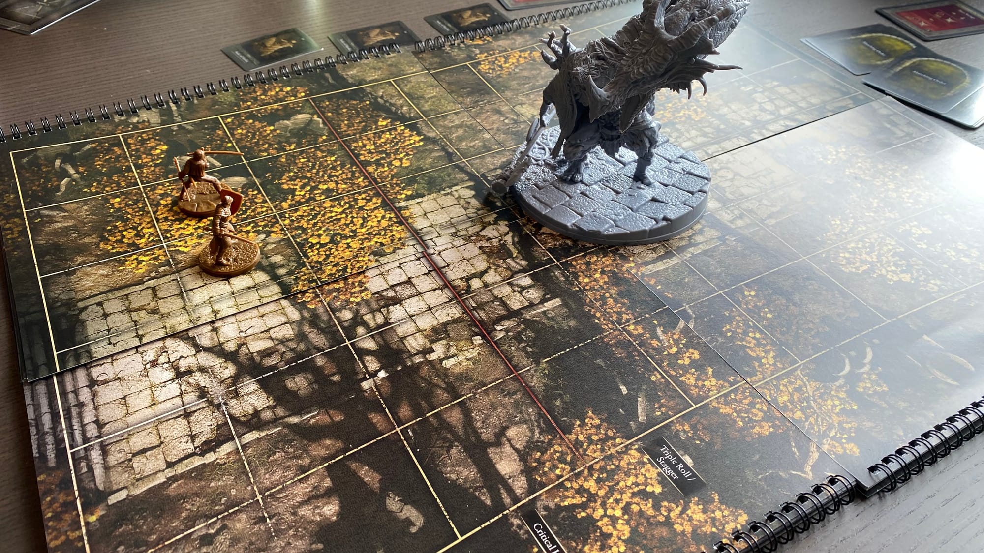 The miniature of Godrick the Grafted towers over the Tarnished minis as he rears up his dragon-arm to unleash fire.