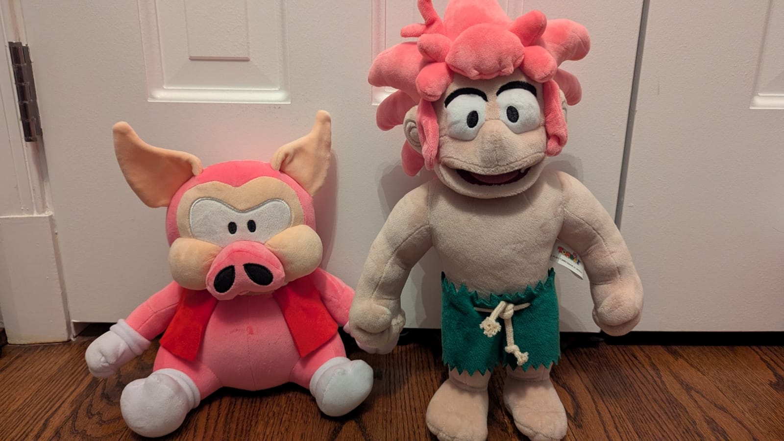 The high quality Koma Pig plush sitting next to the terrifying Tomba plush.