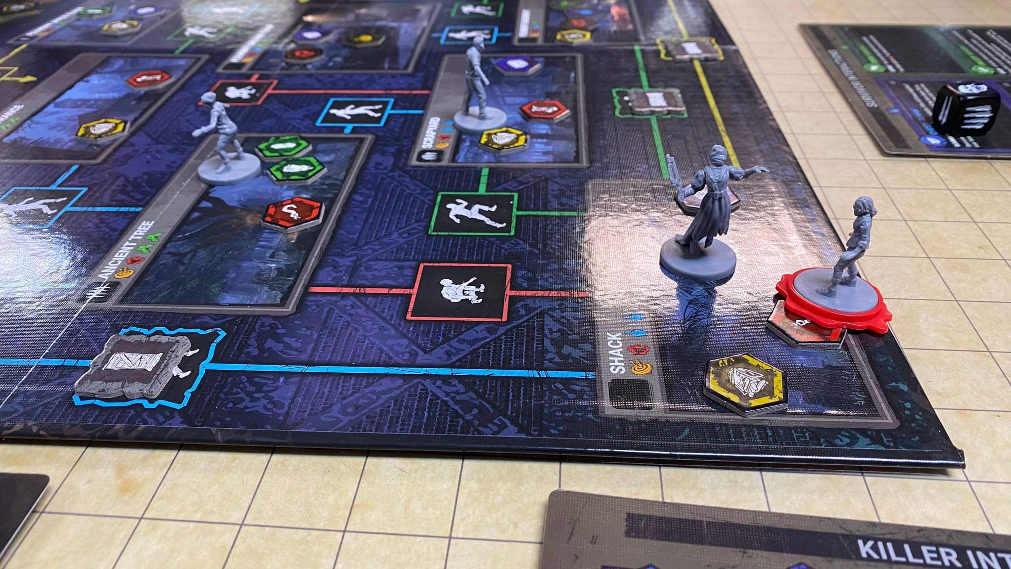 A Survivor is placed on a Hook token. There are several paths into their space, but three of them are blocked by obstacle tokens that the Killer hasn't removed yet.