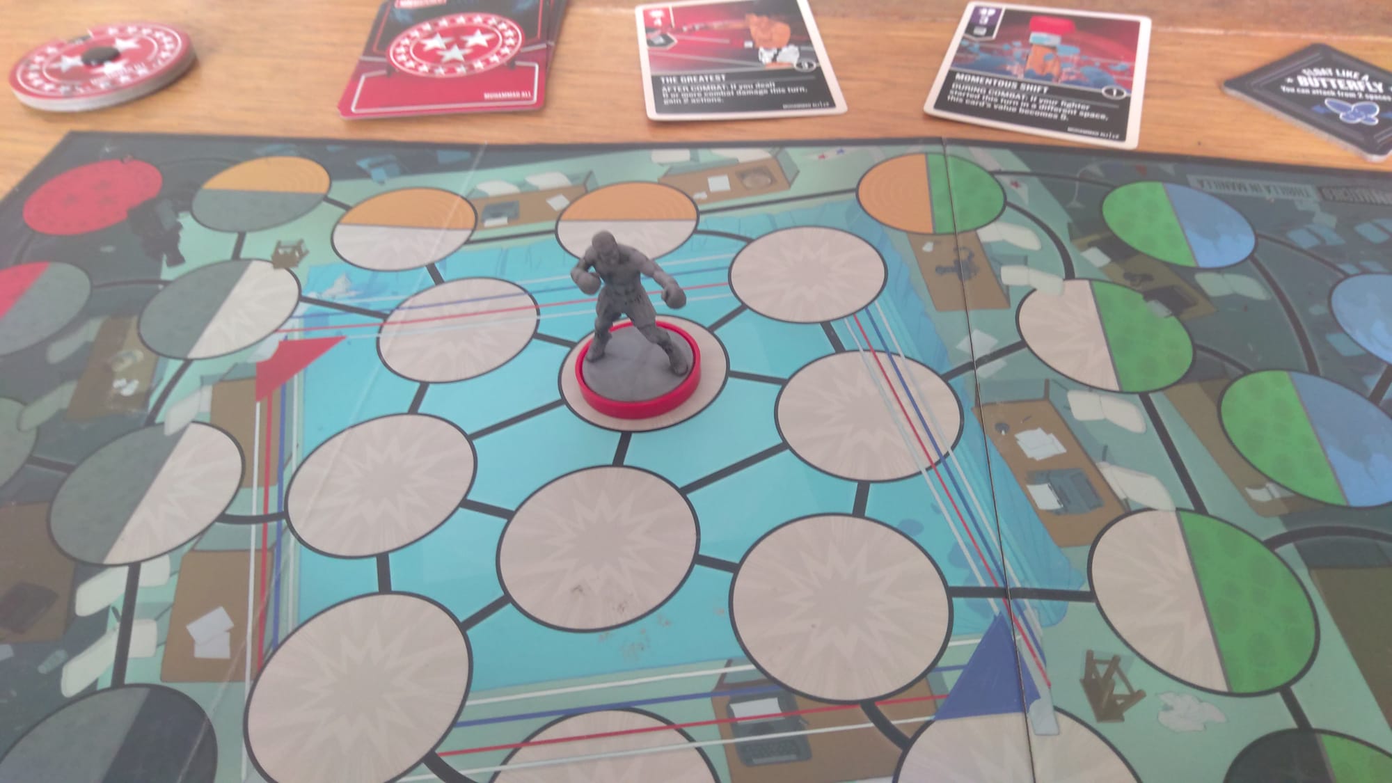 Muhammed Ali on the boxing ring map with his health dial, cards, and stance token in the background