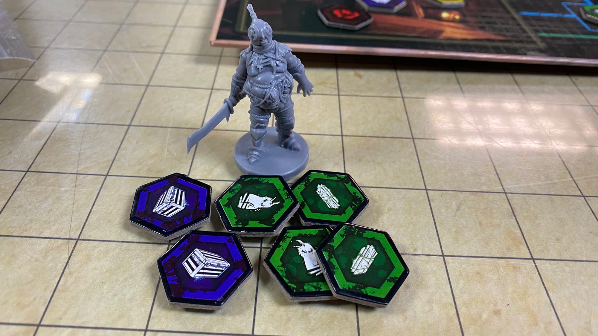 The Carnifex mini standing behind a pile of various prop tokens