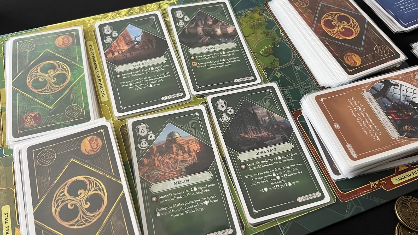 The central board holds the exploration and world forge draw decks as well as the independent strongholds.