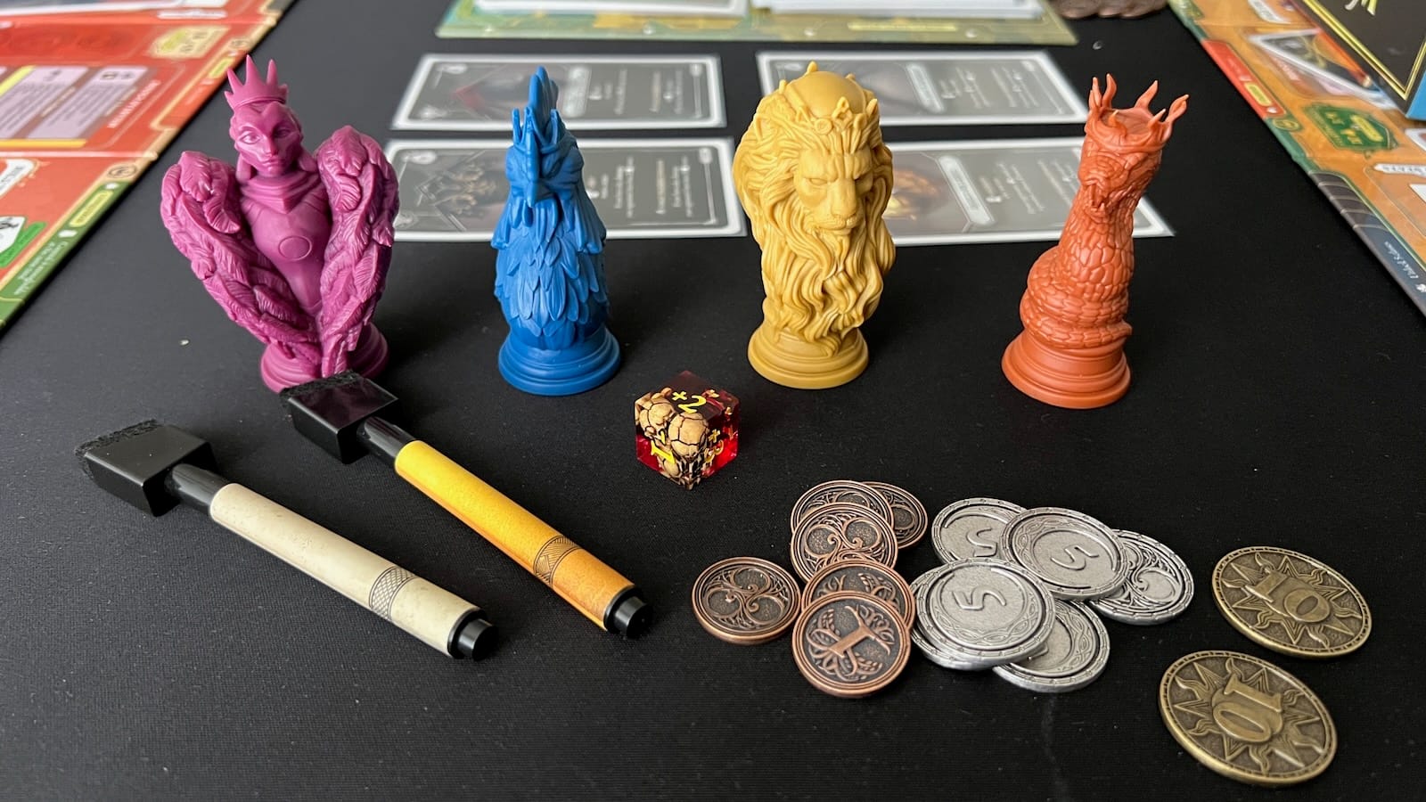 Upgraded components such as skull dice, faction specific markers, metal coins, and faction markers.