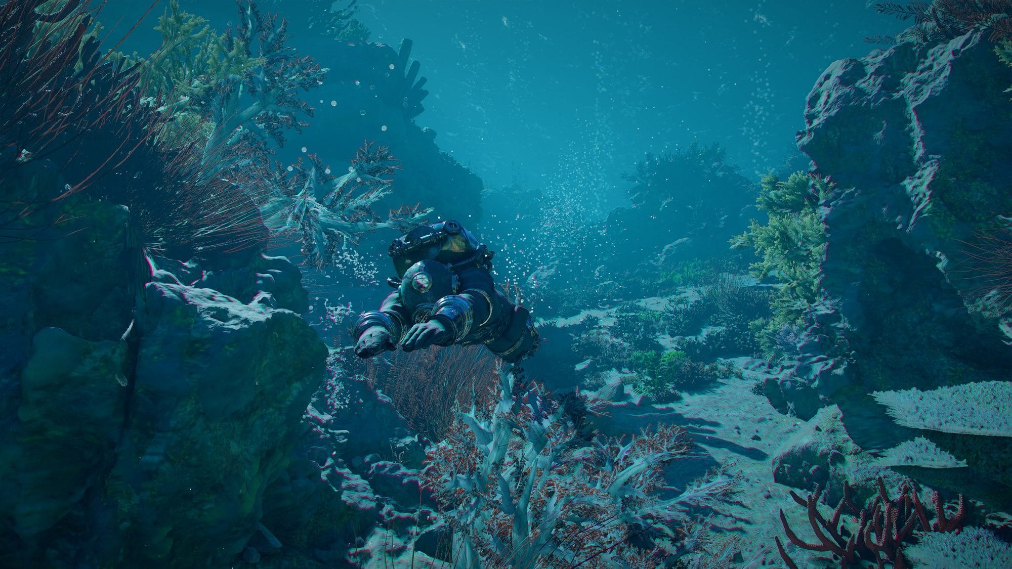 Diver swimming through a coral-lined underwater canyon in deep blue water