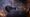 Dark EVE Online warship in an orange and purple nebula firing at a burning asteroid