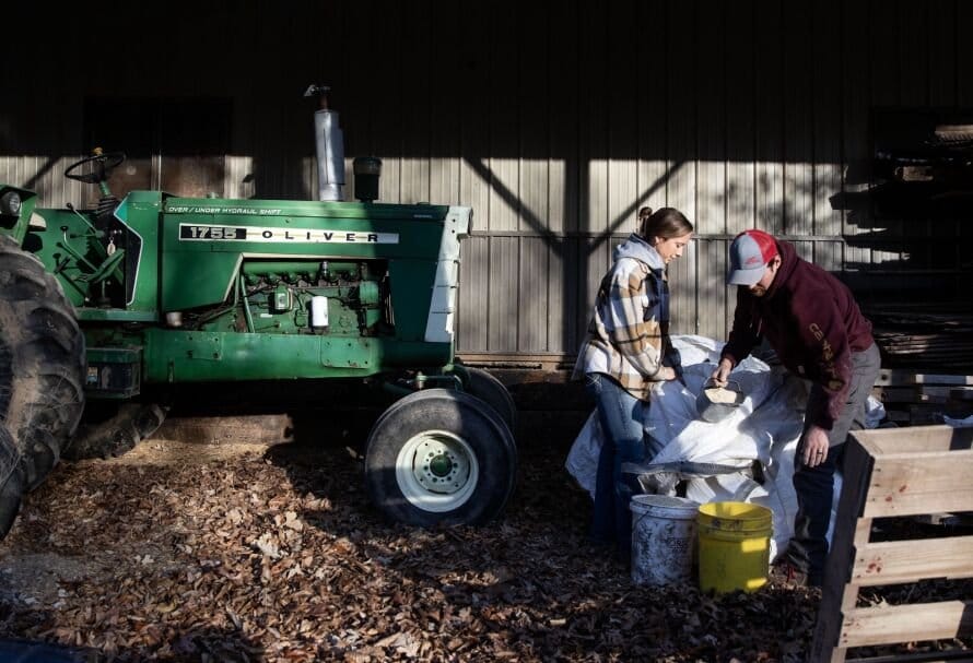 Katherine De Boef and her husband Ben De Boef work together to put chicken feed into buckets before heading out for their