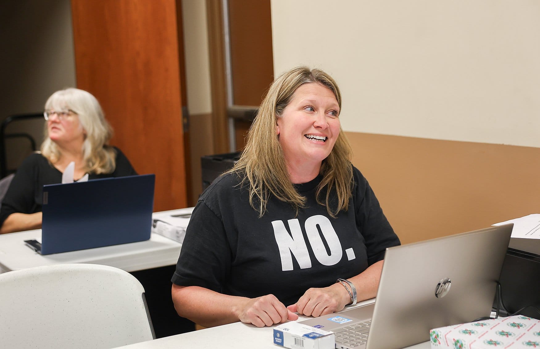 Tammy Ridgley talks to a resident at a desk where people can pick up blank affidavits on Wednesday, April 1, 2026, at the