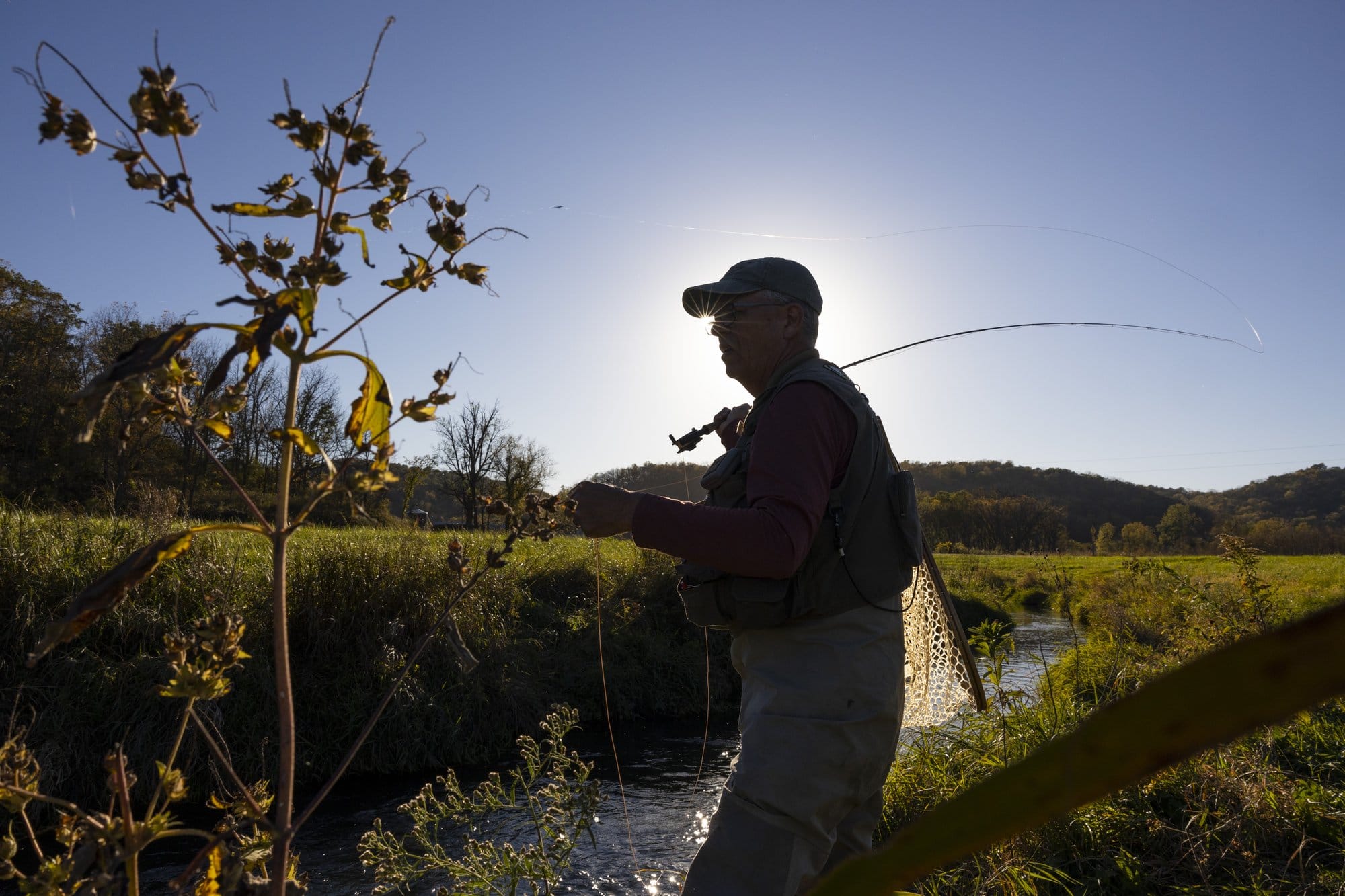 Henry Nehls-Lowe, Southern Wisconsin Trout Unlimited board secretary, casts his fly-fishing line in Sixmile Branch, a Class