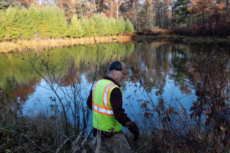 Jim Hoffman, CEO of Hoffman Construction, looks at an artificial beaver lodge he built along a pond on his property.