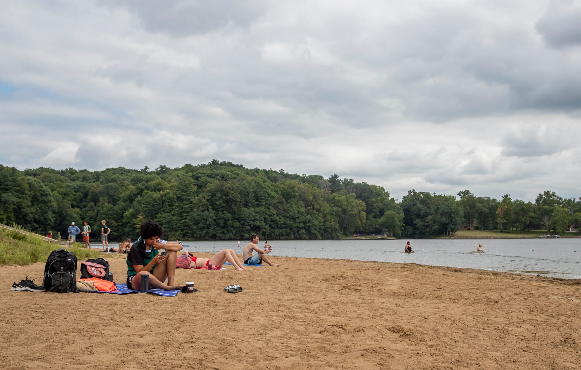 People play on a beach by the river