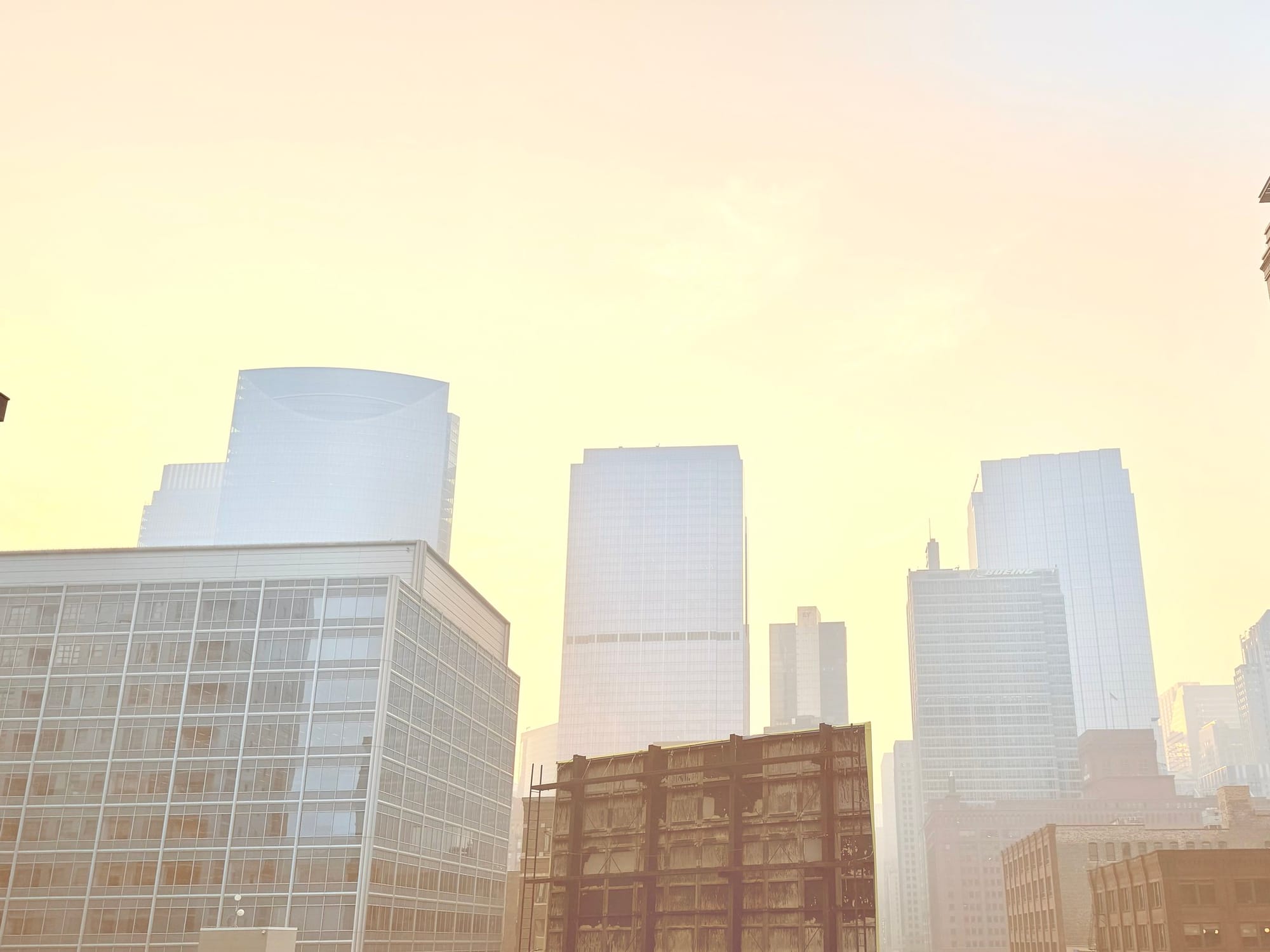 The sky surrounding skyscrapers is hazy and filled with smoke