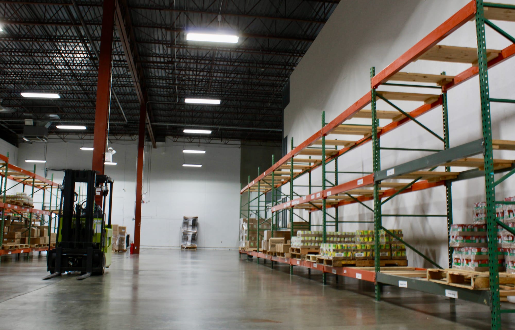 A large warehouse is sparse with crates of food