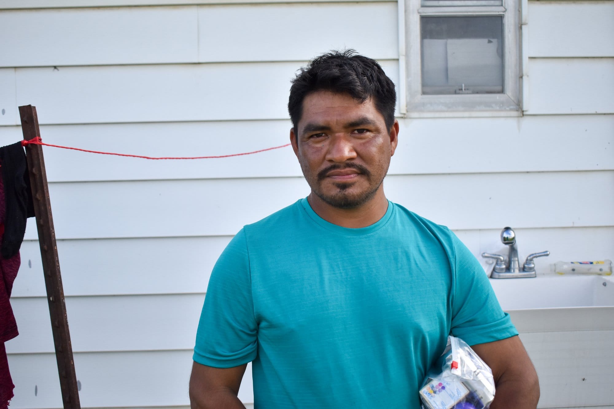 A man stands in front of a house