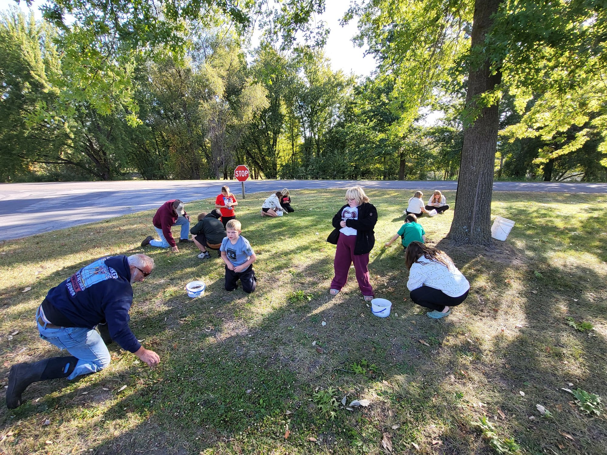Fifth grade students from Prairie View Elementary in De Soto, Wisc kneel down to gather acorns.