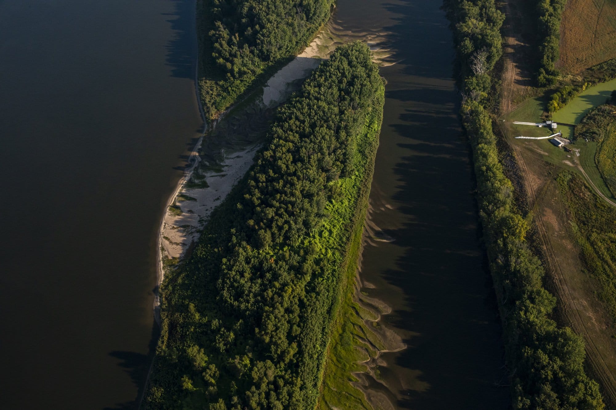 Aerial view of low water in braided channels of the Mississippi River near the Quad Cities of Iowa and Illinois, with exposed sandbars surrounding a tree-covered island.