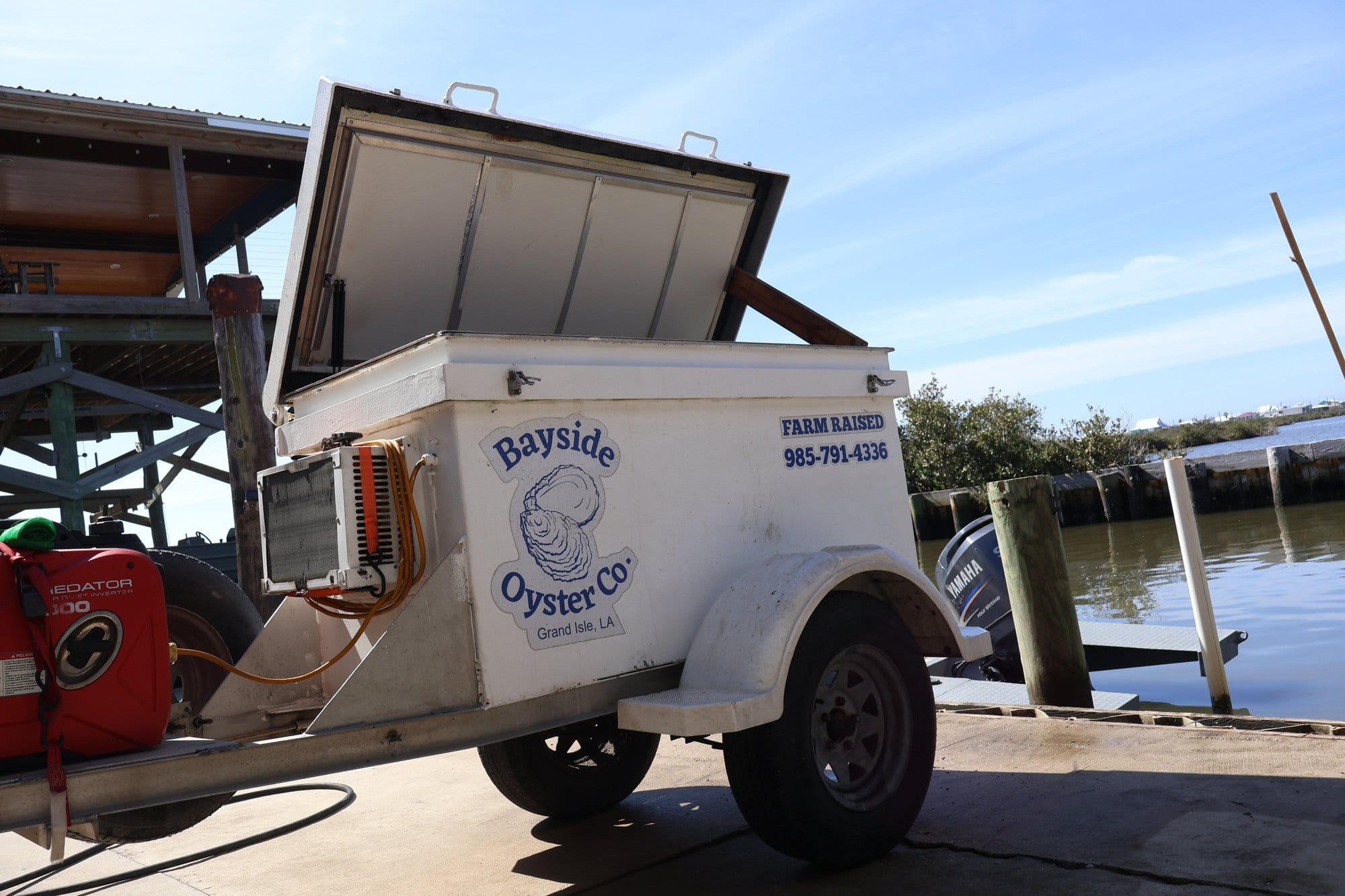 A white transportable cooler used to keep oysters chilled.