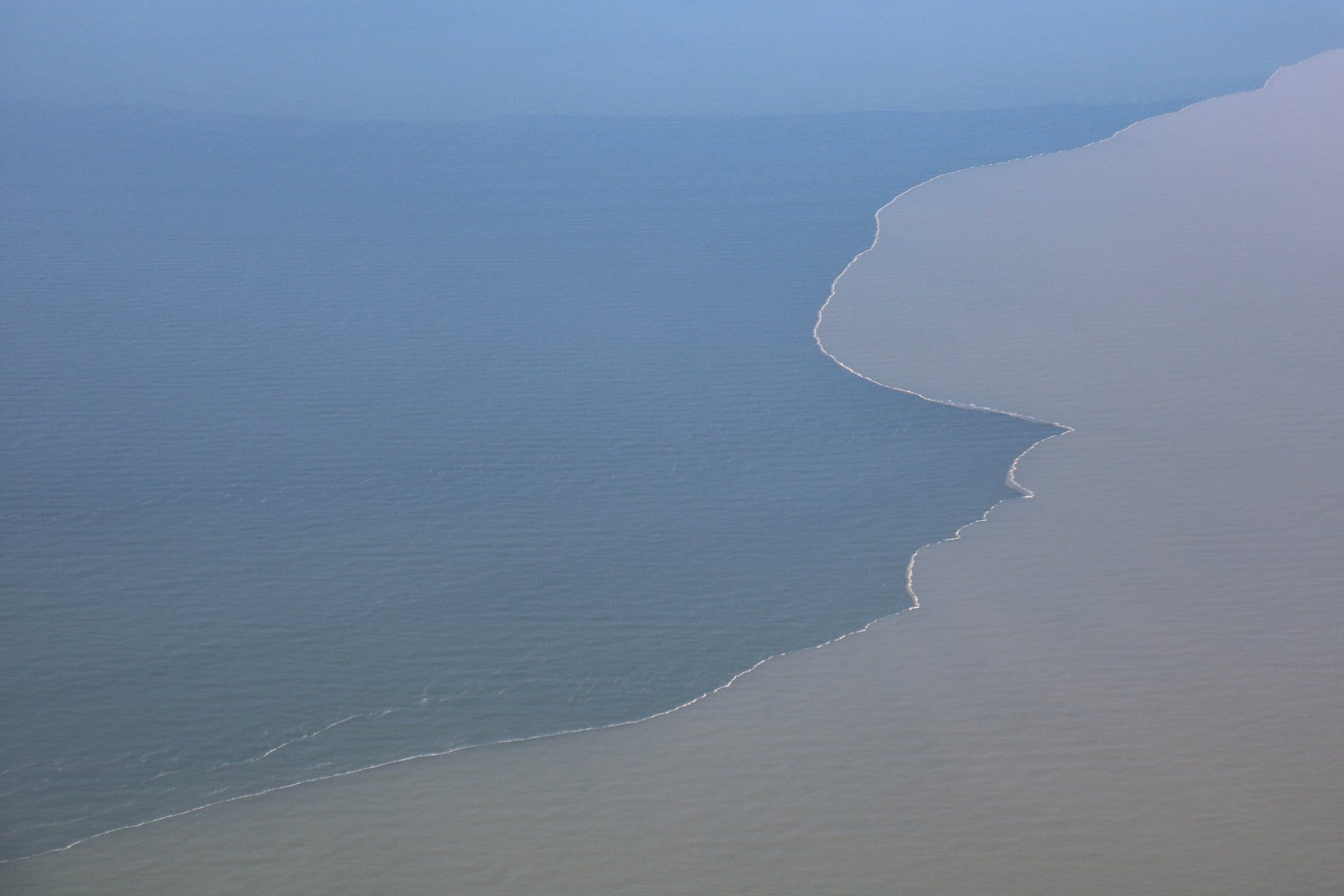 Aerial shot Murky, sediment-rich Mississippi River water mixing with saltwater in the Gulf of Mexico off the coast of Louisiana.