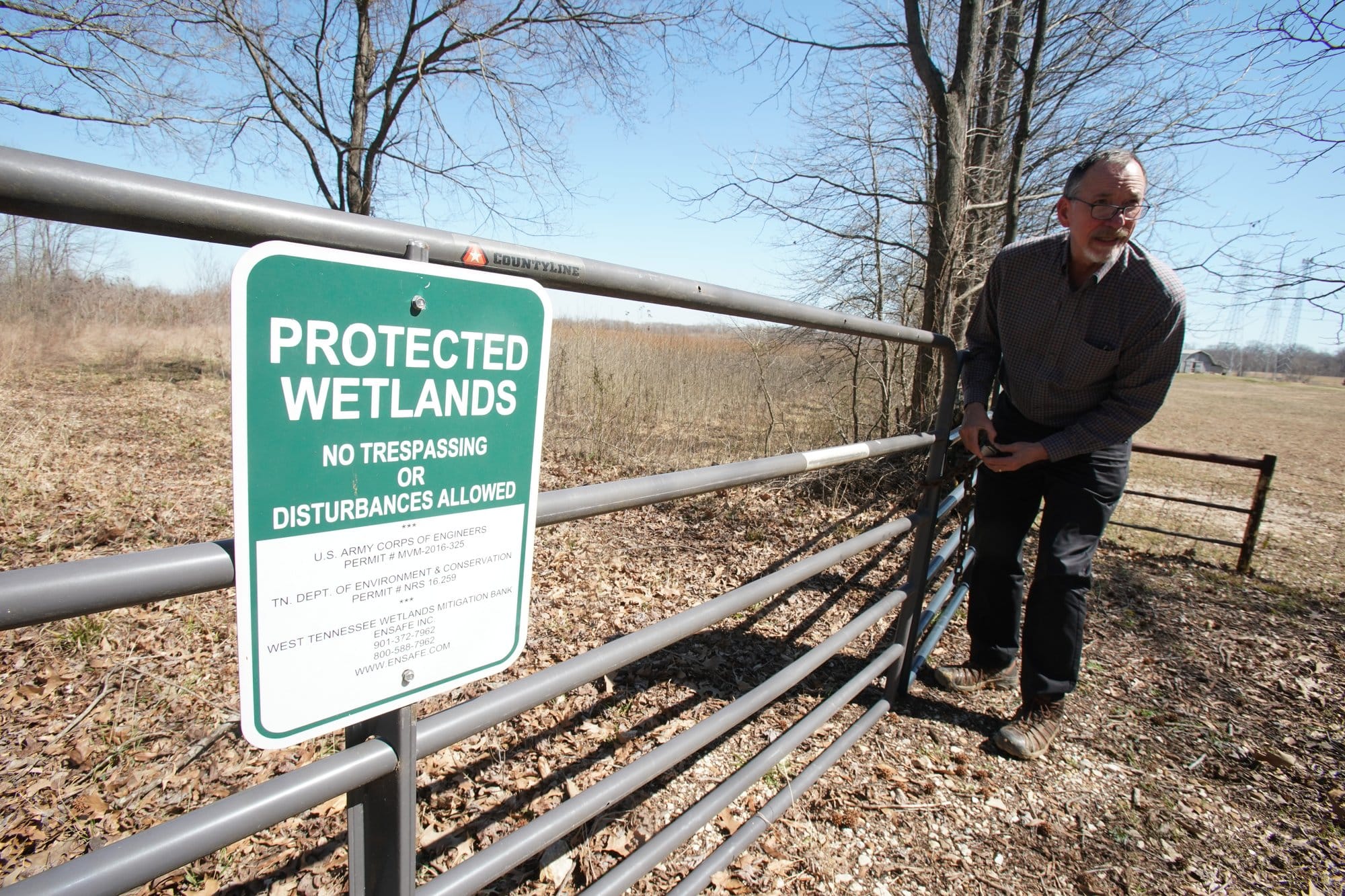 Paul Stoddard, a principal at environmental consulting firm EnSafe, unlocks the gate to the West Tennessee Wetlands Mitigation Bank in Shelby County, Tenn.