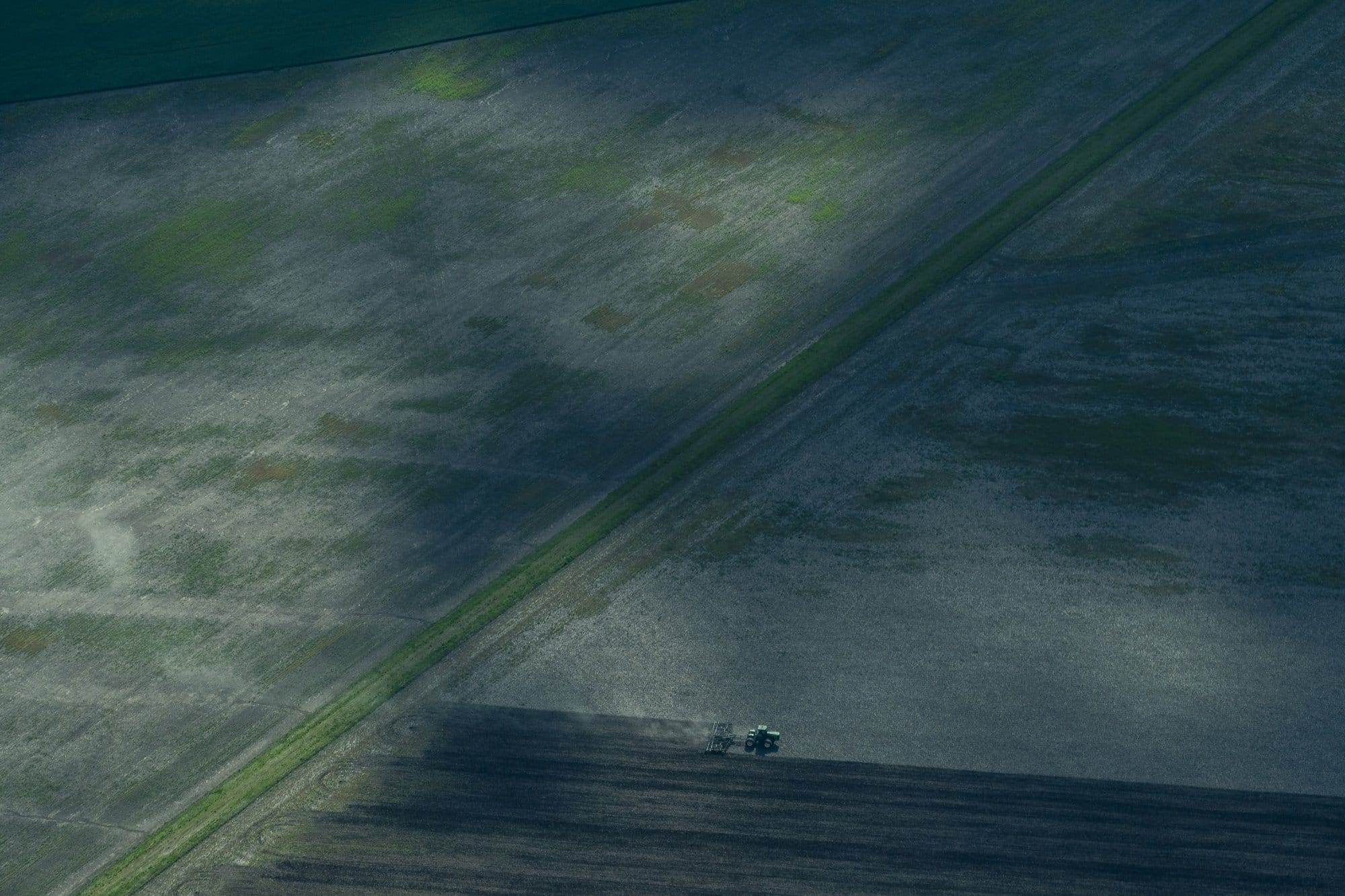 An aerial shot of a tractor tilling farmland in Illinois.