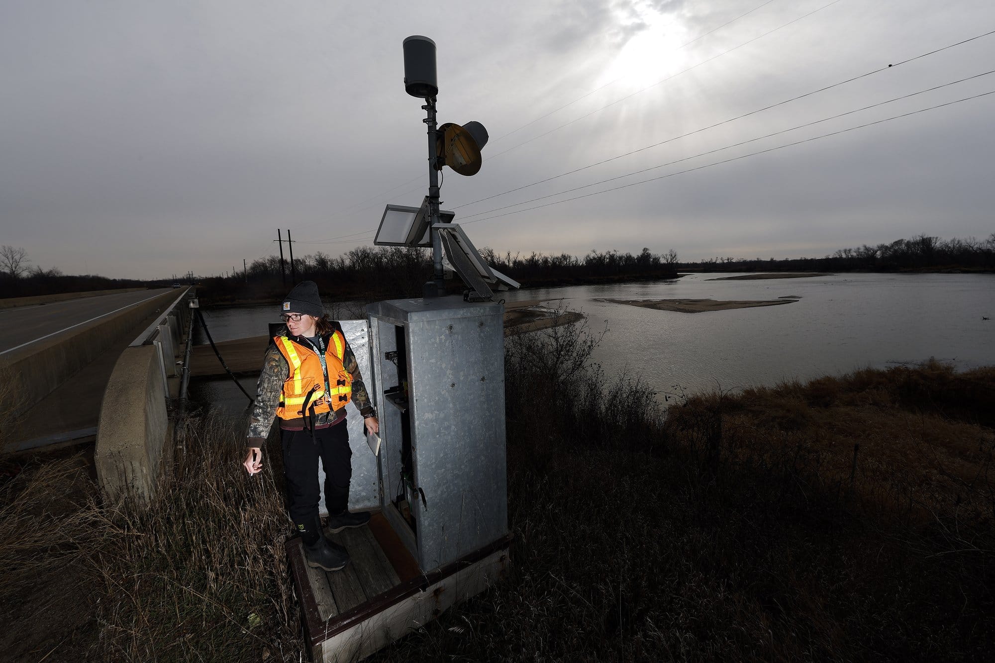 A USGS scientist, check data at a river monitoring station beside the Cedar River near Palo, Iowa.