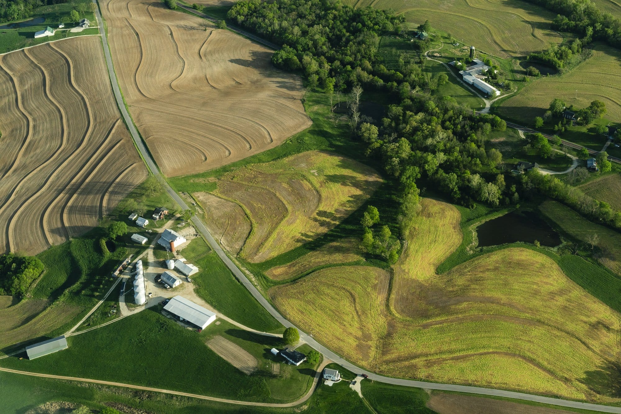Aerial view of farmland, farm buildings, and winding roads near the Missouri river in Washington, Missouri.