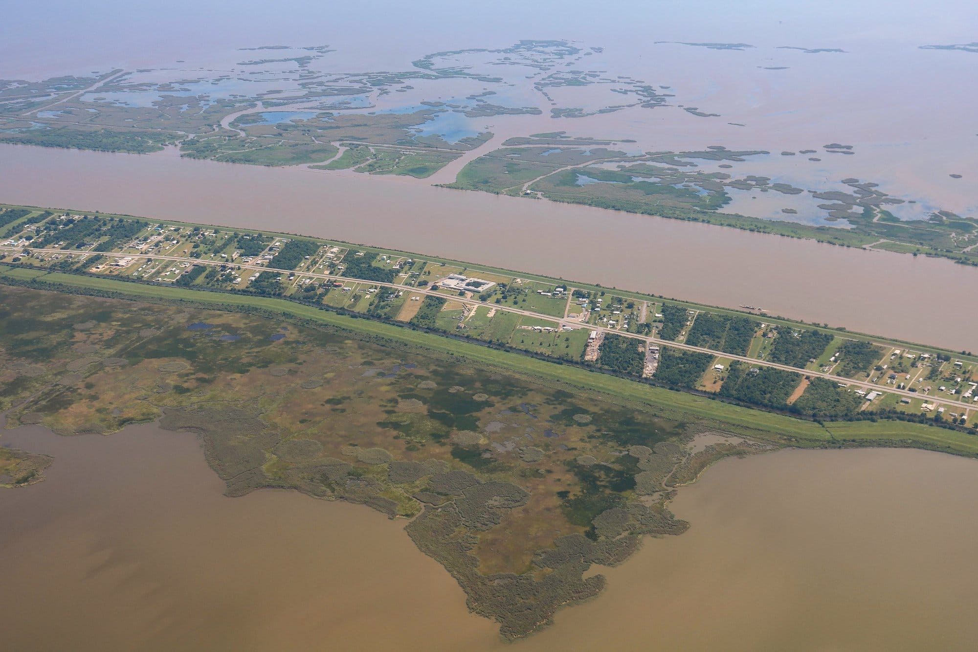An aerial view of Boothville, Louisiana, surrounded by the Mississippi River and fragmented coastal marshes near the Gulf of Mexico.