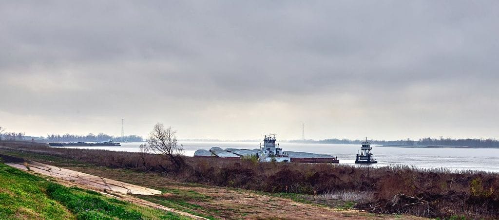A barge goes down the river where water levels are low