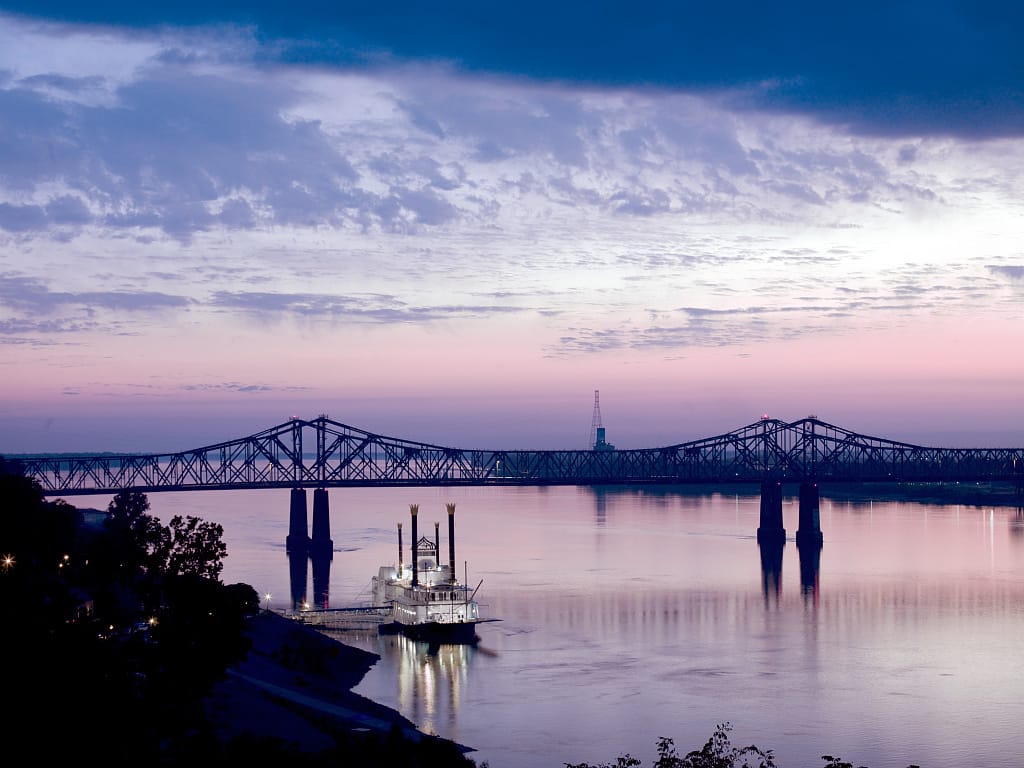 A casino boat floats near a bridge over the Mississippi River