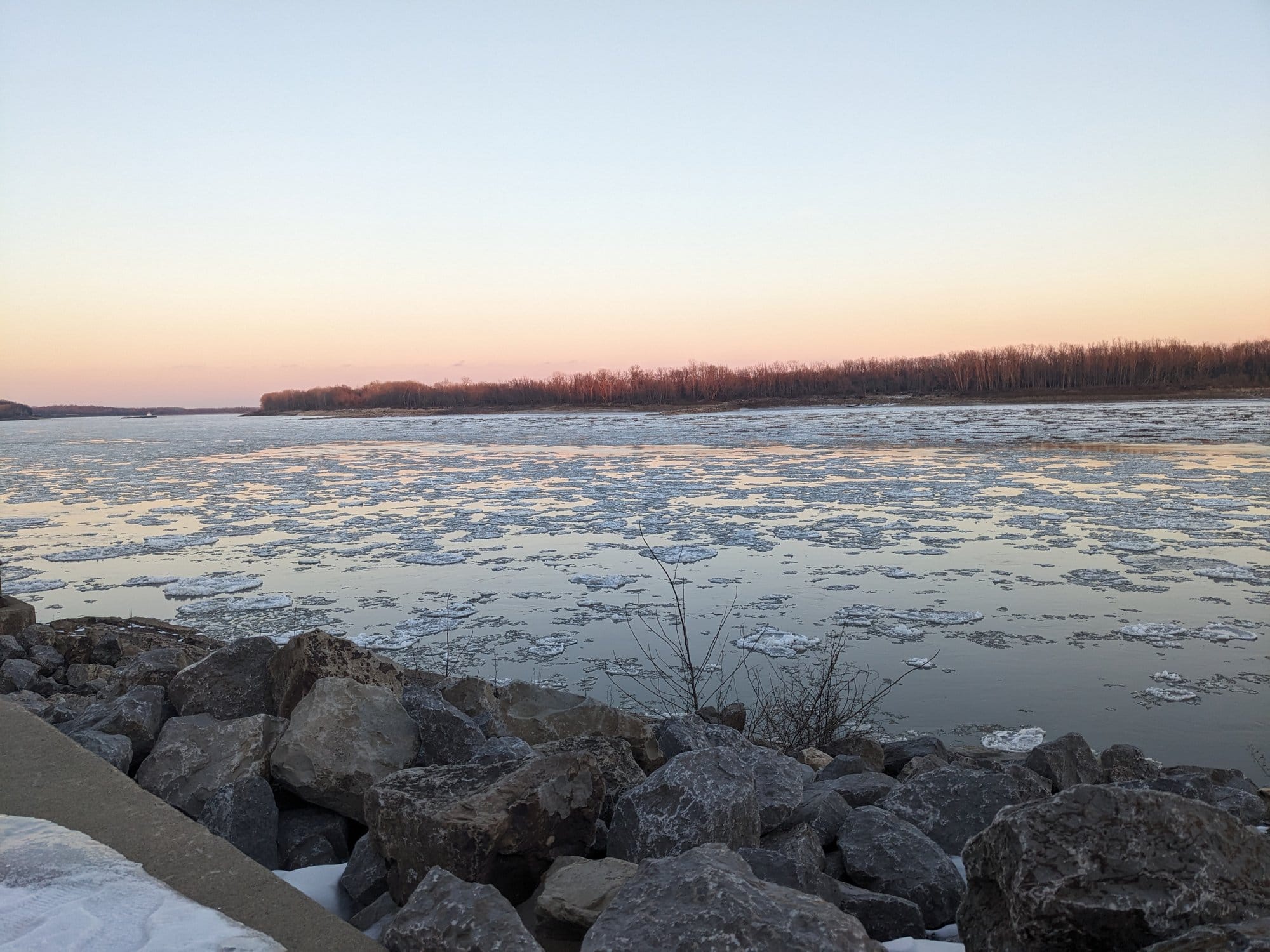 Small pieces of ice float atop a large body of water