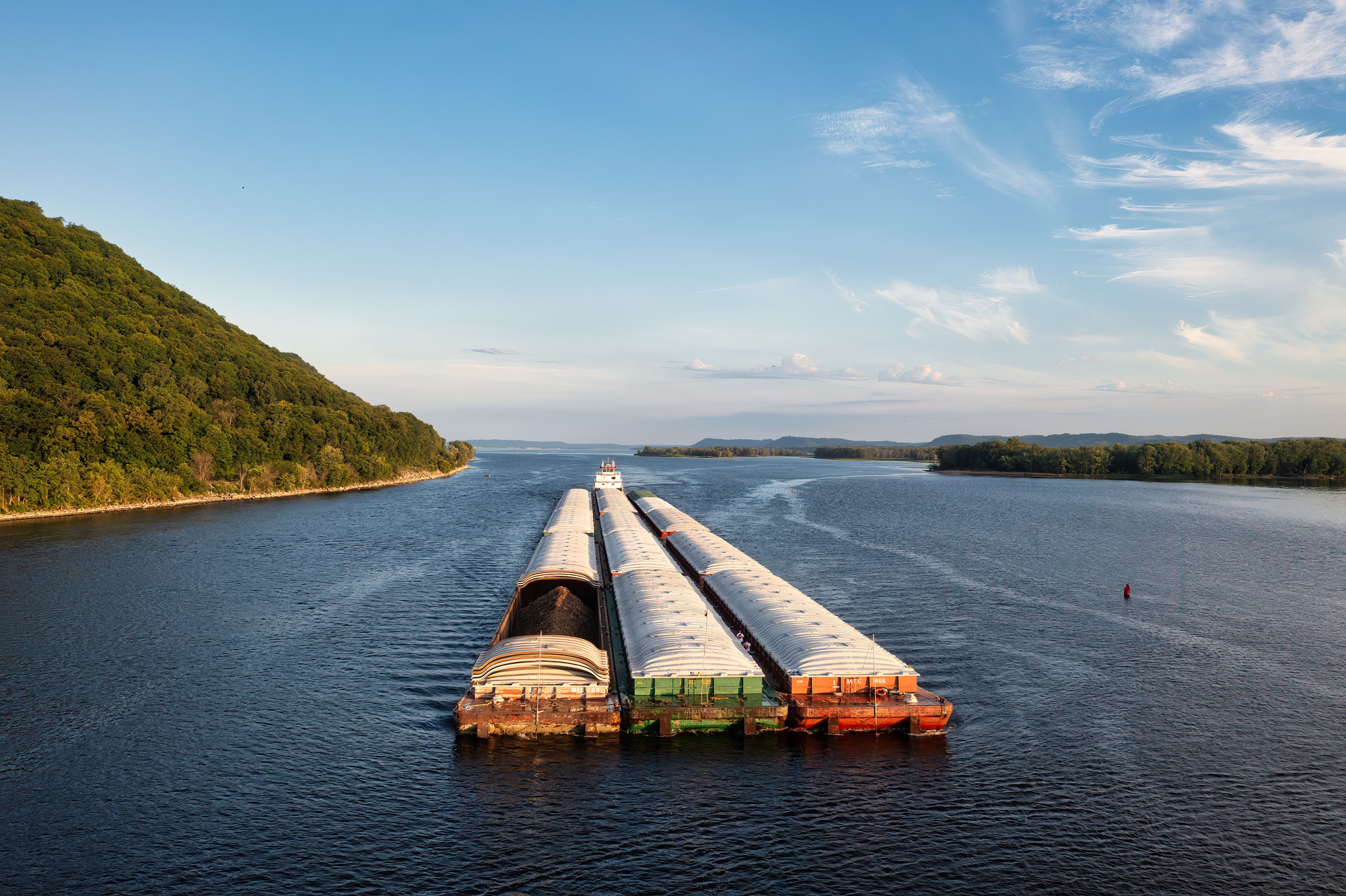 a barge pulls cargo down a river