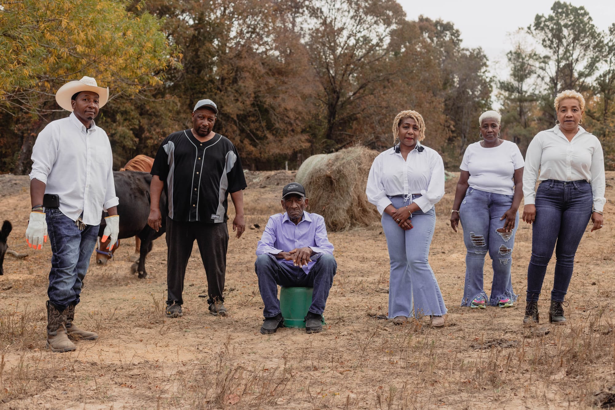 A family of farmers sits in a field